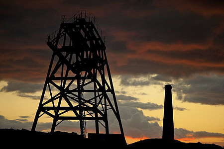silhouette of tower near lighthouse under gray and orange sky thumbnail