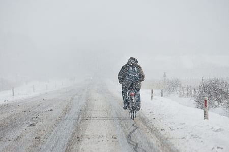 man biking on snow road thumbnail