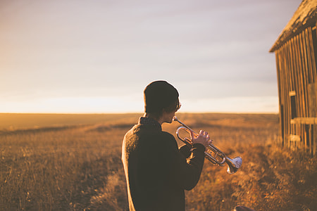man playing trumpet during daytime thumbnail