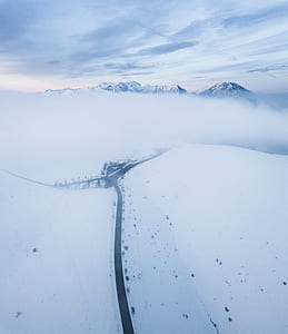 aerial photography of pathway in between mountain covered with snow thumbnail