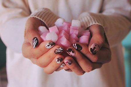 person in white sweater holding pink and white ornaments thumbnail
