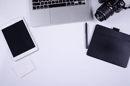 white iPad mini, MacBook Pro, and black DSLR camera thumbnail