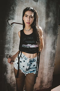 Woman Wearing Black Los Angeles Graphic Crop Top, Blue Denim Stonewashed Cut-off Short Shorts and Black Fishnet Stockings thumbnail