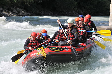 people riding a red and black inflatable boat thumbnail