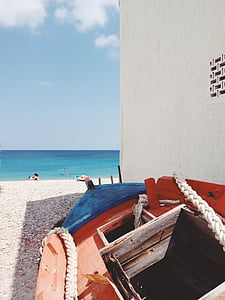 parked boat near building and seashore taken during daytime thumbnail