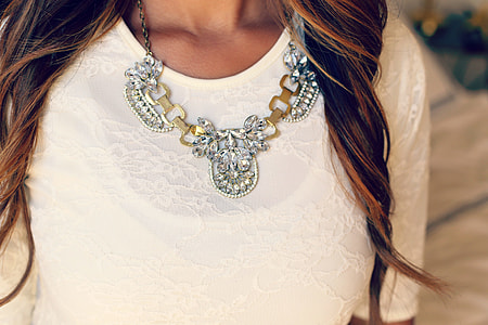 woman wearing beige lace dress and silver beaded necklace thumbnail