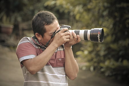 man holding DSLR camera thumbnail