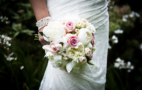 shallow focus photo of woman holding flower bouquet thumbnail