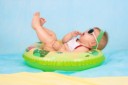 baby lying on green inflatable ring thumbnail