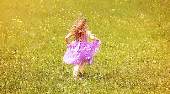 girl wearing pink dress running on grass field thumbnail