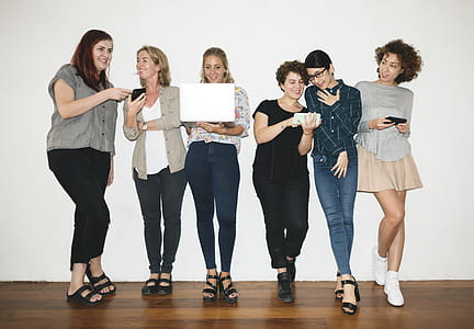 Woman Holding White Laptop Between Women thumbnail