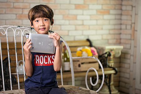 boy holding silver tablet computer thumbnail