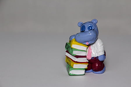 blue hippopotamus leaning on books table figurine thumbnail