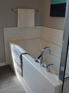 white ceramic bathtub with white towel hanged on silver towel bar thumbnail