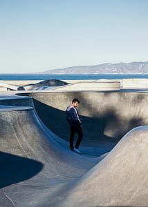 man standing on skateboard ramp during daytime thumbnail