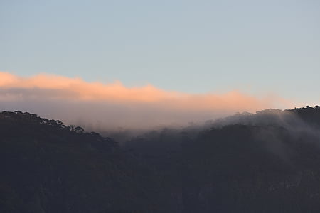 black mountain covered by clouds at daytime thumbnail