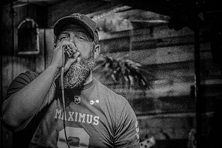 Monochrome Photography of Man Holding Microphone thumbnail