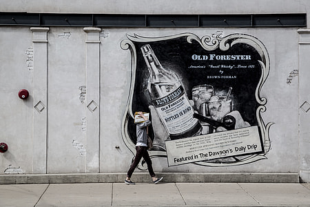 person walking beside black graffiti thumbnail