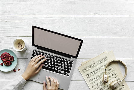 person's hand on laptop keyboard beside cup of coffee thumbnail