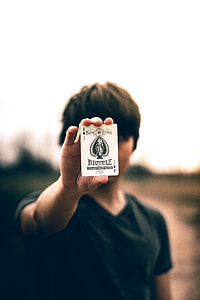 selective focus photography of person holding Ace of spades thumbnail