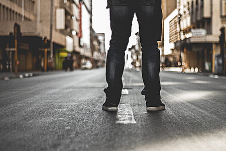 person in black jeans standing on road thumbnail