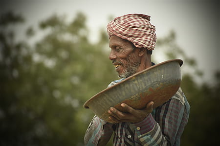selective focus photography of man holding grey basin thumbnail