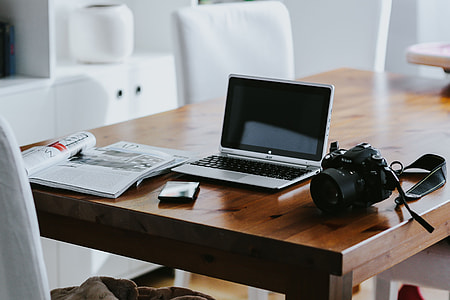 Silver laptop with various items on a table thumbnail