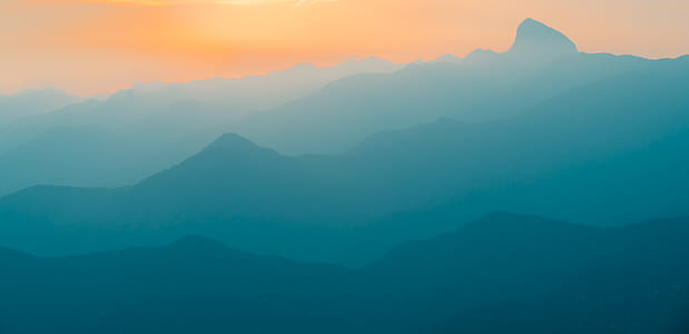 silhouette of mountain covered by fog thumbnail