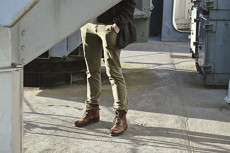 man standing wearing green jeans and brown shoes thumbnail