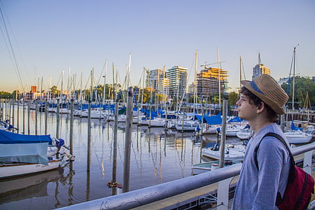 man standing at the pier while looking at the bay thumbnail