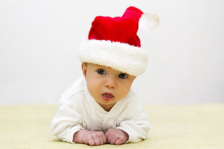 baby wearing red Santa hat crawling on floor thumbnail