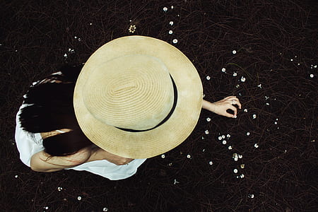 woman wearing brown hat picking white flowers thumbnail