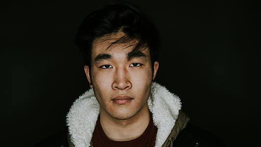 man in black jacket against black background thumbnail