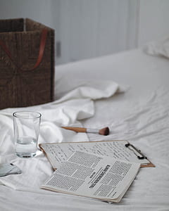 clear shot glass beside brown clipboard thumbnail