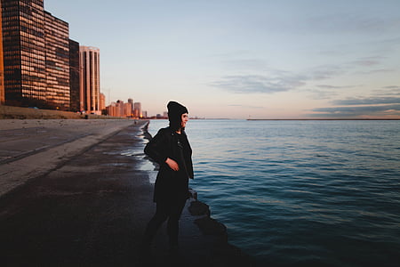 woman beside body of water at daytime thumbnail