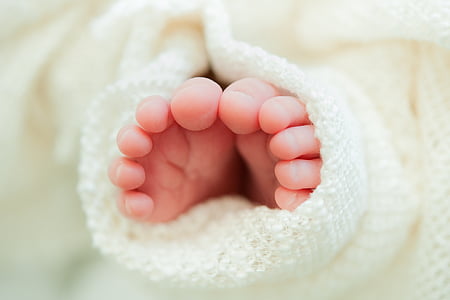 baby's feet on white textile thumbnail