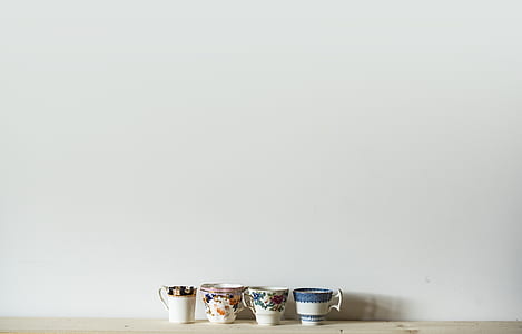 four ceramic cups on wooden desk thumbnail