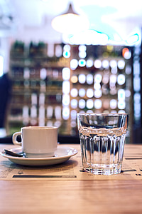shallow focus photography of clear drinking glass beside teacup with saucer thumbnail