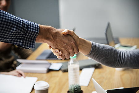 Two Person Doing Handshake Beside Table Inside Room thumbnail