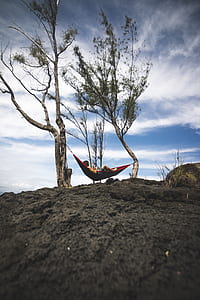 person lying on red hammock thumbnail