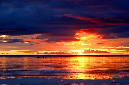 silhouette of boat on body of water during sunset thumbnail