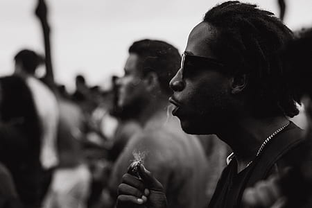 grayscape photo of man holding cigarette stick thumbnail