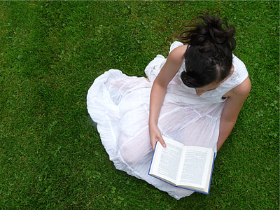 woman seating on grass reading book thumbnail