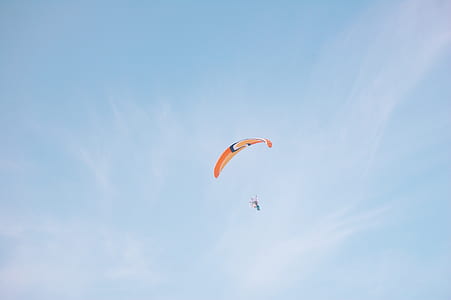 person flying in sky using parachute under blue sky thumbnail