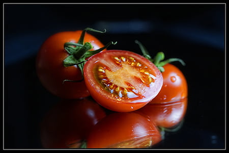 three sliced tomatoes on top of black surface thumbnail