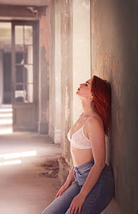 woman wearing white brassiere leaning on wall thumbnail