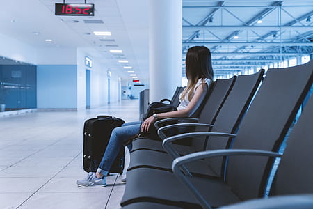 Young girl with long hair is sitting in airport. thumbnail