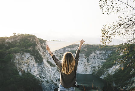 woman in gray sweatshirt near on rock formation thumbnail