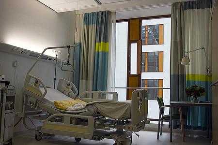 gray hospital bed near blue and gray window curtain inside room thumbnail