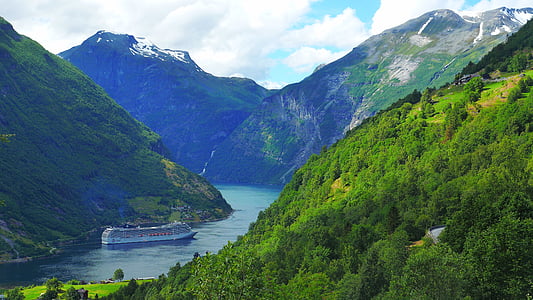 white cruise ship on body of water near green covered mountain thumbnail